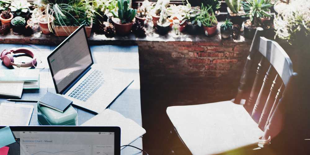 table with laptops and an empty chair