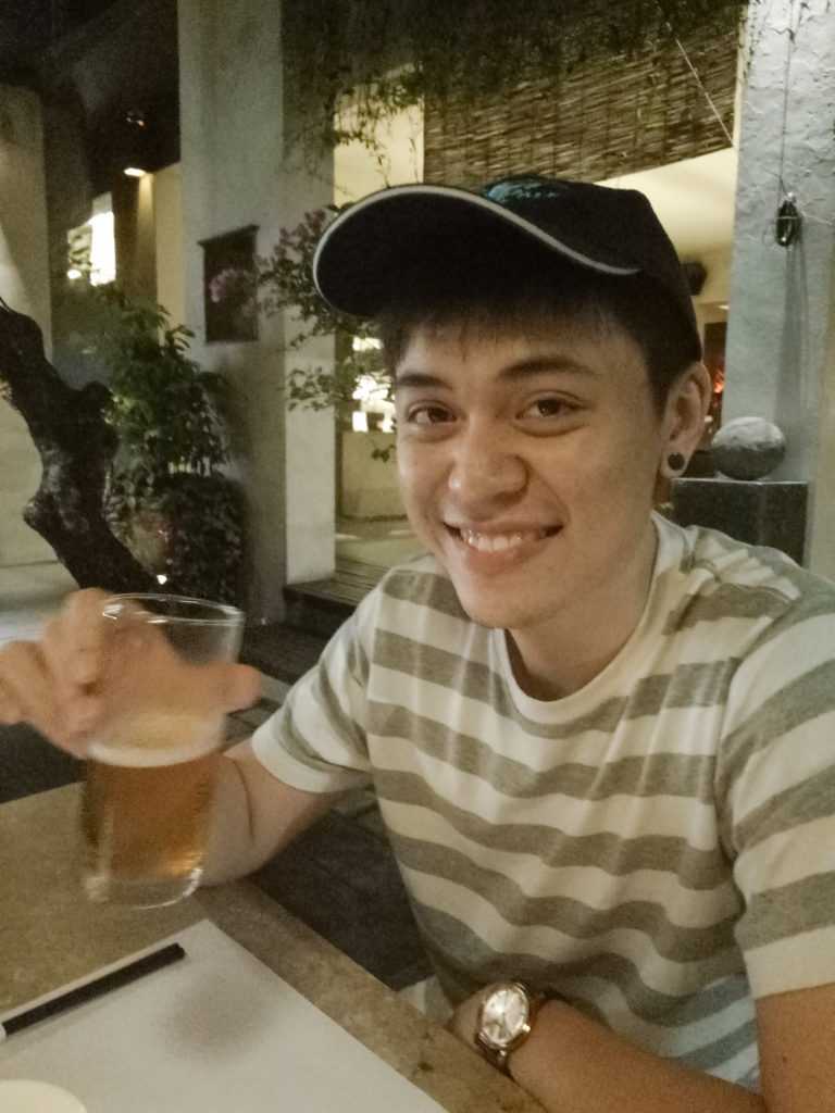 nick ang first photo with earring and beer in hand in bali restaurant
