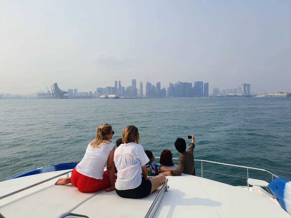 photo of my and some friends on a boat with the Singapore city skyline in the background